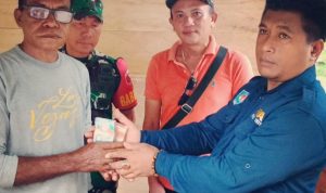 Camat Oba Selatan Safruddin Nasir menyerahkan uang ganti rugi kepada pemilik lahan (foto/sn)